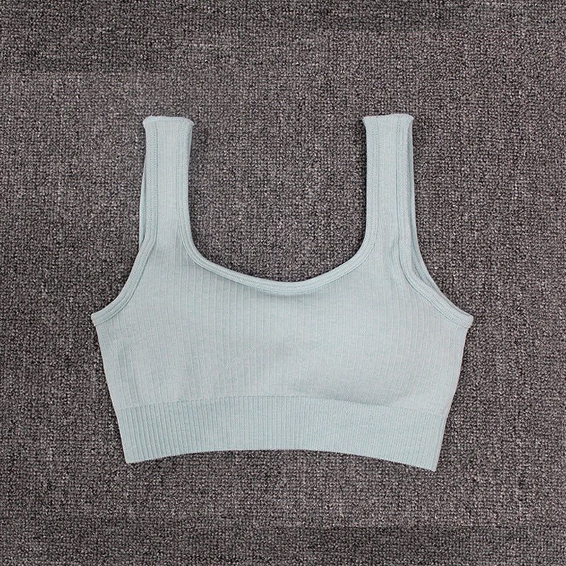 Seamless fitness bra for women on a textured background.