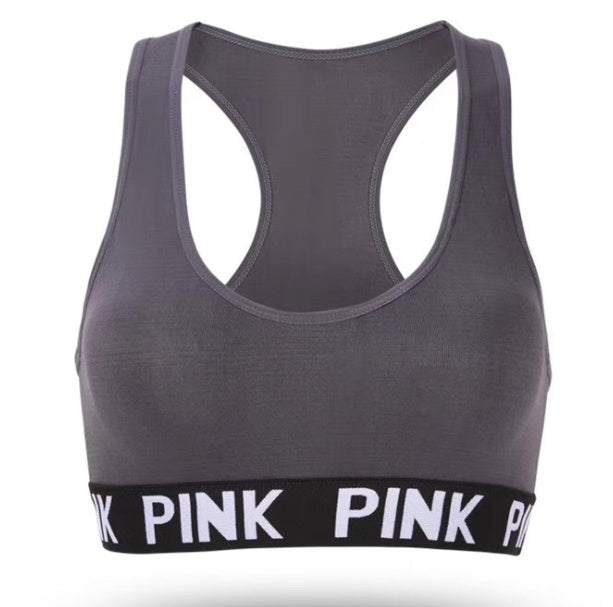 Training Pro Women Sports Bra in dark gray with pink branded band, designed for comfort and support.