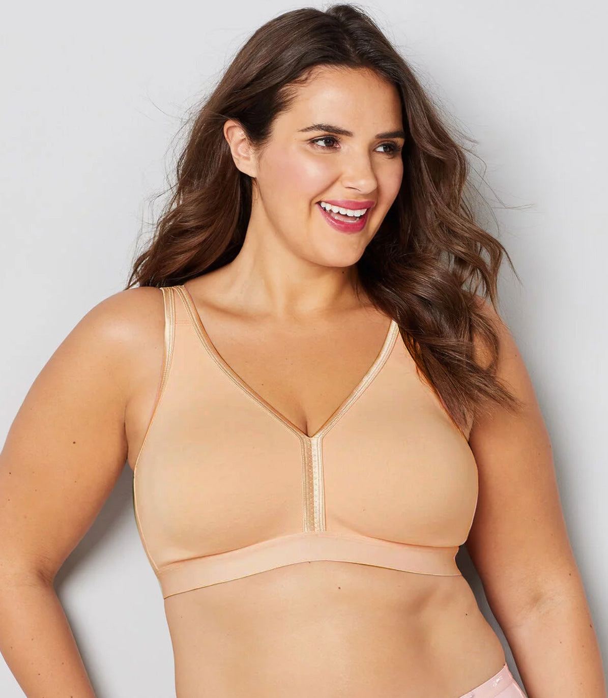 Women wearing a full cup large size bra in peach color made of cotton.